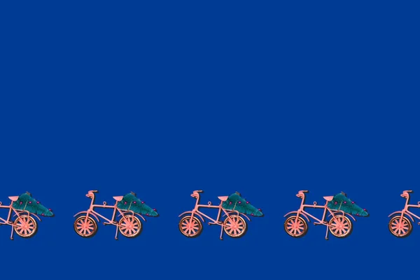 Pattern with bicycle moving Christmas tree on classic blue. Holiday celebration card concept with place for text — Stock Photo, Image