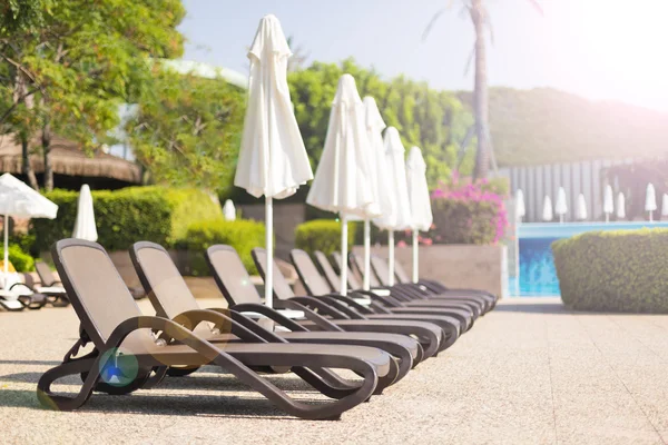 Camas de sol perto de uma piscina — Fotografia de Stock