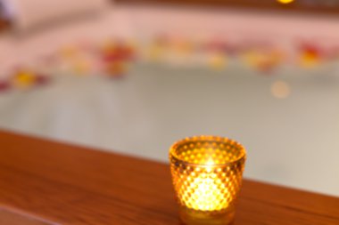 Jakuzi yakınındaki bir cam Mumluk mum. Geri bulanıklık