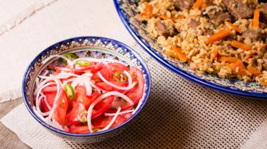 Pilav ve achichuk ahşap arka plan olarak el yapımı tabak salata