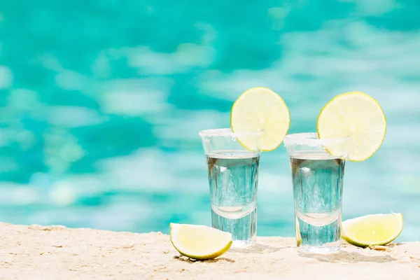 Tequila colpi con calce su sfondo blu — Foto Stock