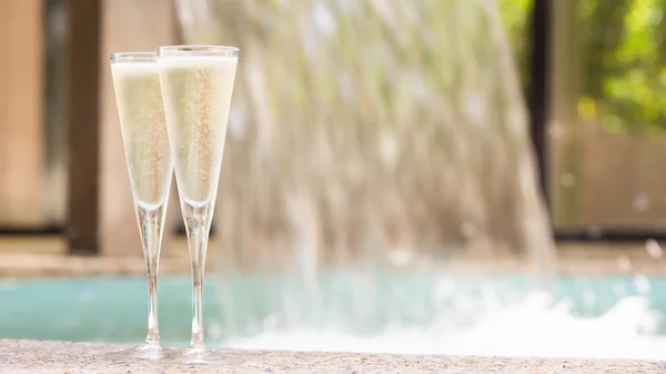 Dos copas de champán cerca de jacuzzi al aire libre — Foto de Stock