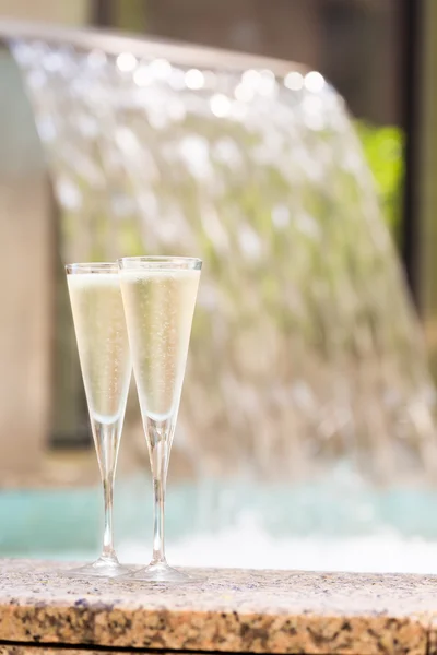 Två glas champagne nära utomhusjacuzzi — Stockfoto
