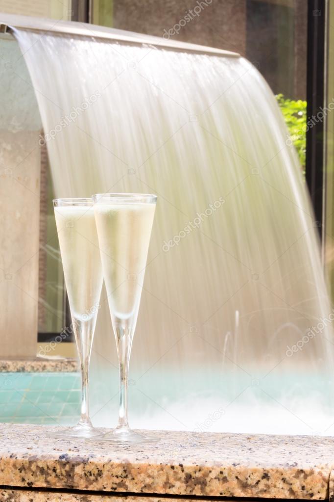 Two glasses of champagne near outdoor jacuzzi