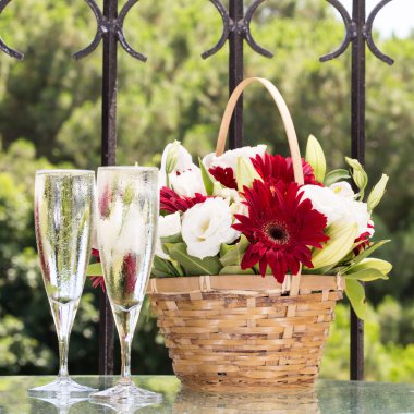İki bardak champange ve çiçek sepeti