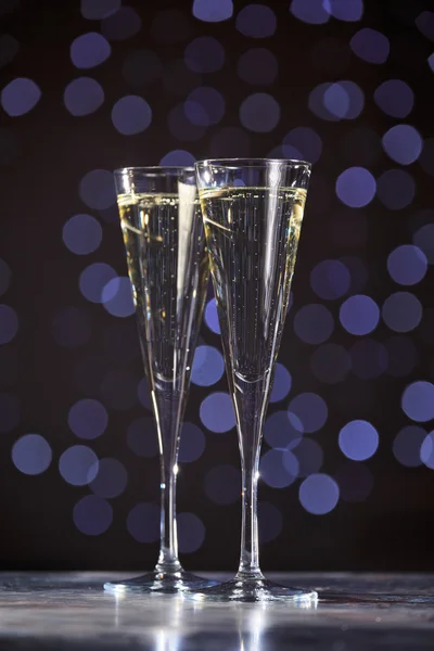 Two glasses of champagne on dark bokeh background — Stock Photo, Image