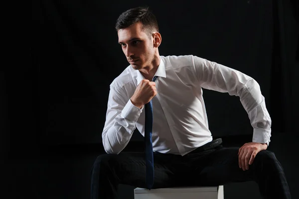 Um homem de camisa branca com gravata em fundo preto — Fotografia de Stock