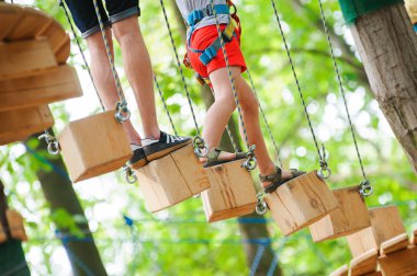 Bir çocuk bir yetişkin eşliğinde ipleri rotada hareket eder.