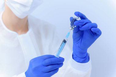 Şırıngayı ilaçla dolduran doktor, yakın çekim. Aşılama ve aşılama