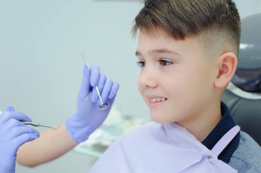 Diş muayenehanesinde dişçisi olan bir çocuk.