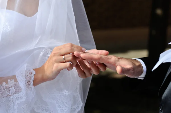 Bride putting a wedding ring on a groom's finger — Stock Photo, Image