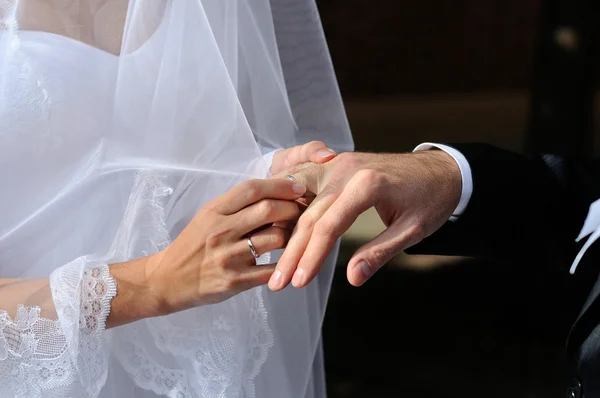 Bride putting a wedding ring on a groom's finger — Stock Photo, Image