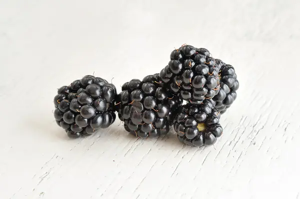 Moras sobre fondo de madera blanca — Foto de Stock