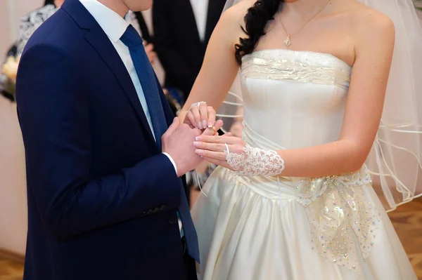 Bride putting a wedding ring on a groom's finger — Stock Photo, Image