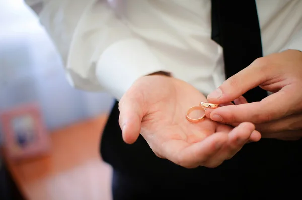 Groom segurando um anel de ouro — Fotografia de Stock