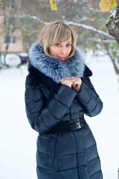 Portret van een meisje op de straat in de winter met sneeuw — Stockfoto