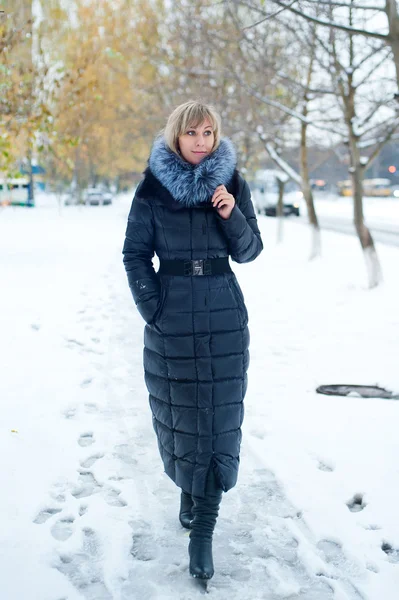 Meisje loopt op een besneeuwde straat — Stockfoto