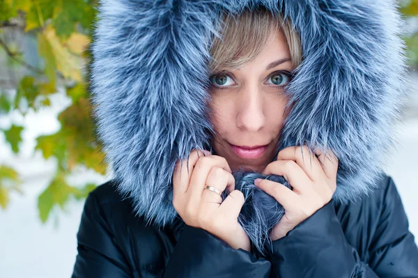 Portret van een meisje op de straat in de winter met sneeuw — Stockfoto