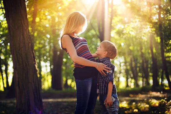 Mama i synek w parku lub lasu, na zewnątrz. Przytulanie i h — Zdjęcie stockowe