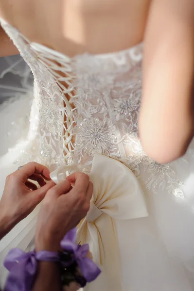 Dama de honor está ayudando a la novia a vestirse — Foto de Stock
