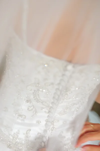 Bridesmaid is helping the bride to dress — Stock Photo, Image