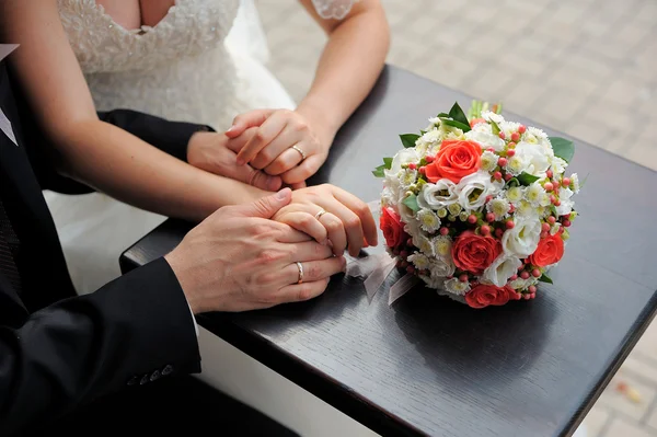 Brud- och brudgummen håller varandra i handen — Stockfoto