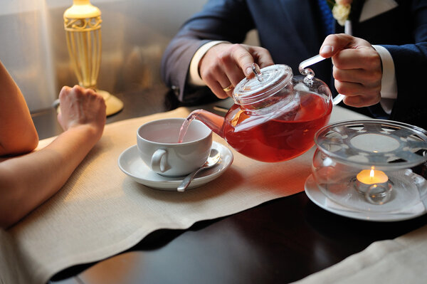 A man pours tea into a cup