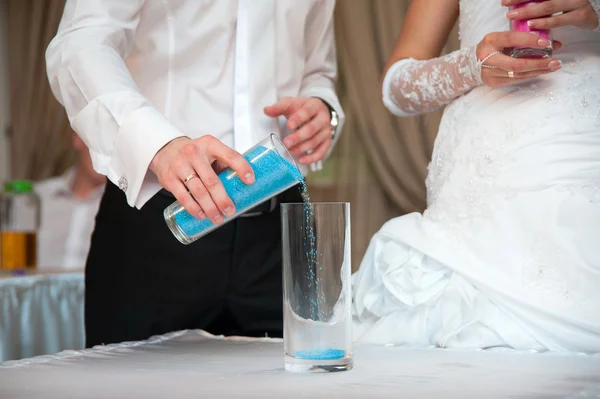 Hands of bride and groom doing sand ceremony during wedding — Stock Photo, Image