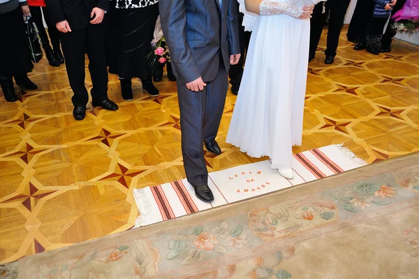 Bruden och brudgummen är på broderade handduken — Stockfoto