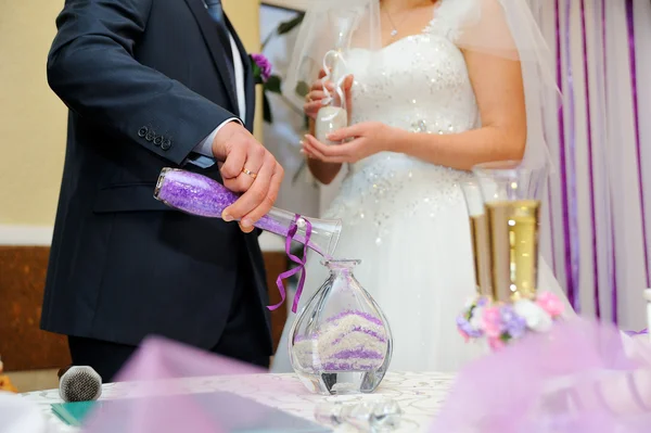 Hands of bride and groom doing sand ceremony during wedding — Stock Photo, Image