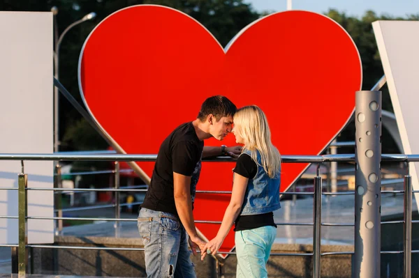 Pareja amorosa con un gran corazón detrás de ellos — Foto de Stock