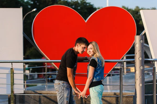 Casal amoroso com um grande coração atrás deles — Fotografia de Stock