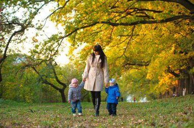 Anne Çocuk twins sonbahar parkta bir yürüyüş ile