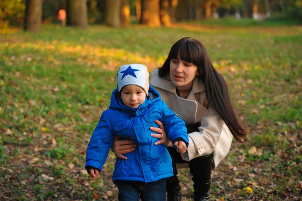 Mother with kid on a walk in the autumn park — Stock Photo, Image