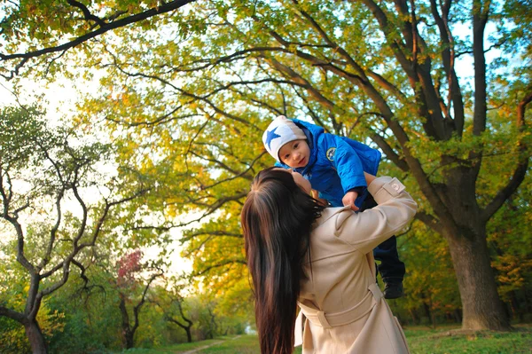 Mamma lancia il bambino. fioritura lilla, comunicazione madre e bambino, jo — Foto Stock
