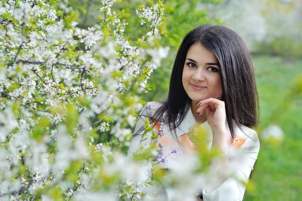 Menina bonito caminha no jardim da primavera — Fotografia de Stock