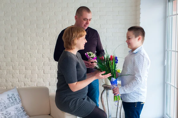 Niño dando flores a su madre en el día de la madre — Foto de Stock