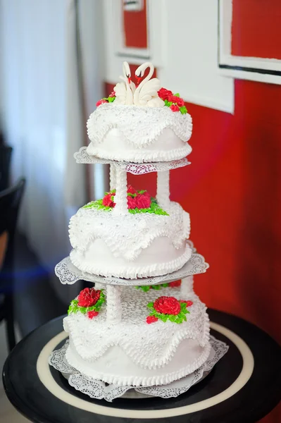 Свадебный торт с фигурками лебедей сверху — стоковое фото