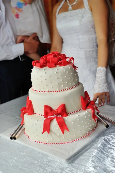 Noiva e noivo na recepção do casamento cortando o bolo de casamento — Fotografia de Stock