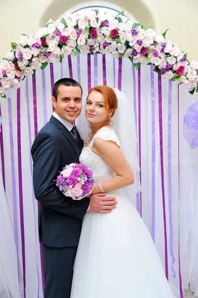 Bride and groom at a wedding ceremony under the arch — Stock Photo, Image