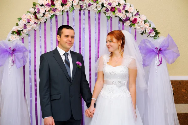 Bride and groom at a wedding ceremony under the arch — Stock Photo, Image