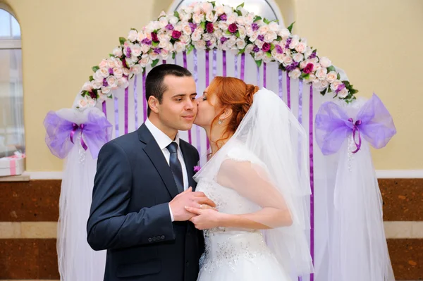 Bride and groom at a wedding ceremony under the arch — Stock Photo, Image