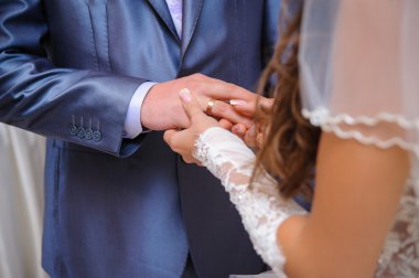 Gelin Damat'ın parmağında alyans koyarak