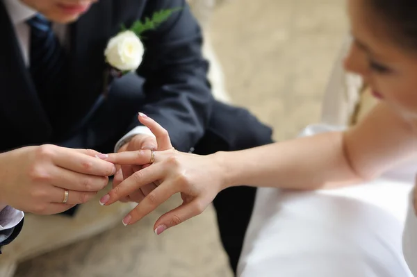 Novio poniendo anillo en el dedo de la novia — Foto de Stock