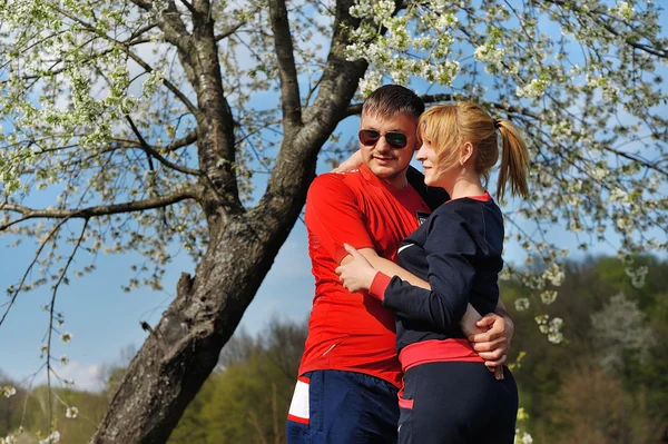 Pareja cariñosa en el floreciente jardín de primavera — Foto de Stock