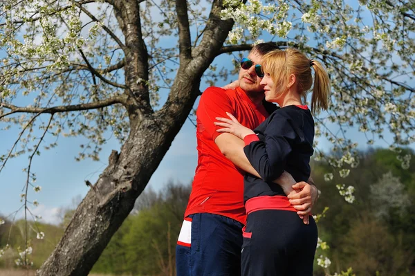 Älskande par i blommande våren trädgård — Stockfoto