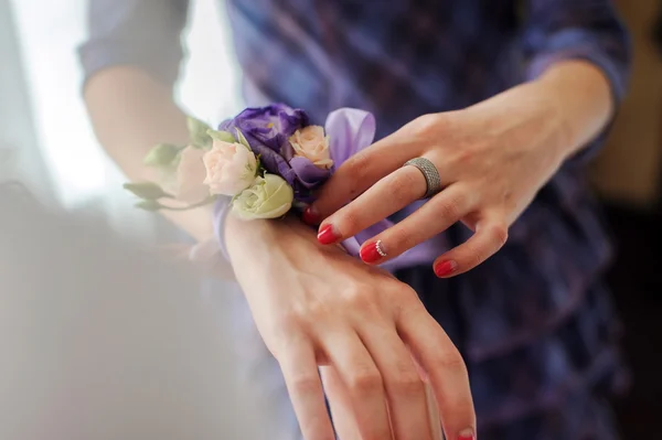 Brautjungfer zeigt boutonniere auf hand — Stockfoto