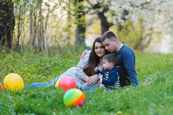 Jonge gezin met zoon in de tuin — Stockfoto