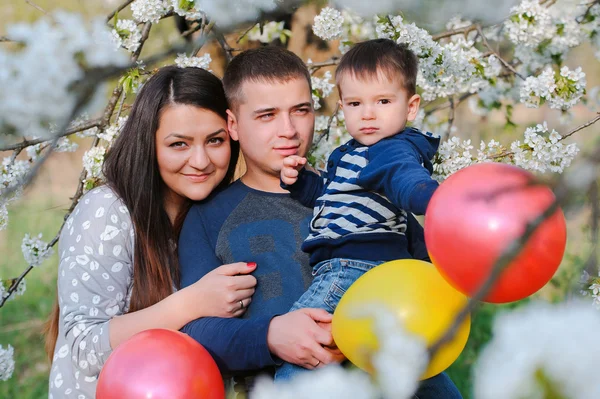 Portret de familie în aer liber în grădina de primăvară înfloritoare cu culoare — Fotografie, imagine de stoc