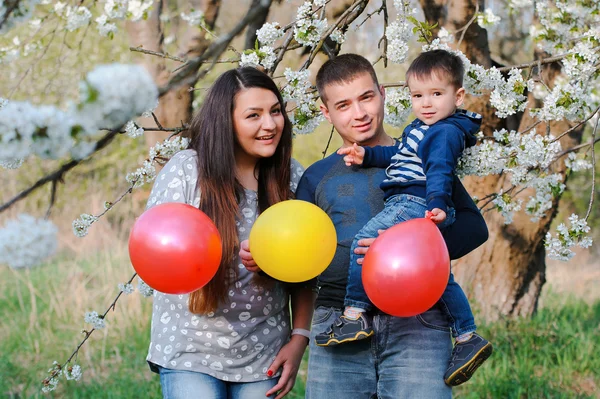 Portret van familie buiten tijdens de bloei lente tuin met kleur — Stockfoto